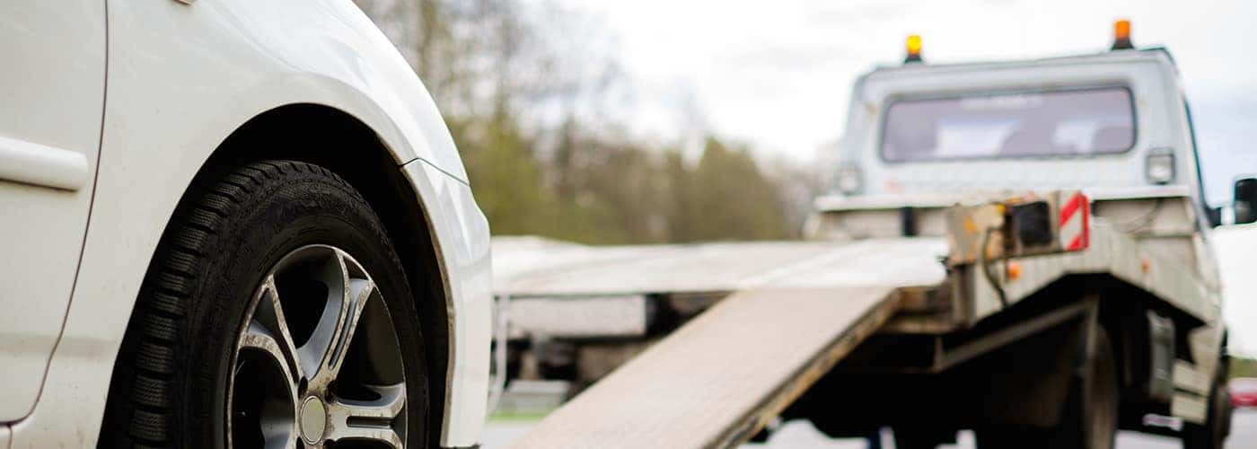 Loading broken car on a tow truck on a roadside