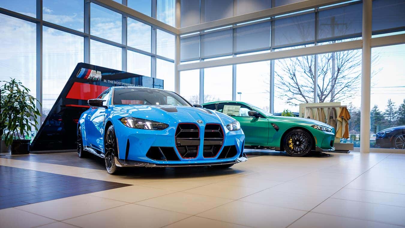 Angled View of two BMW M4 CS Coupes in a BMW Showroom.