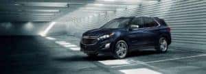 A blue 2021 Chevrolet Equinox parked inside a parking garage