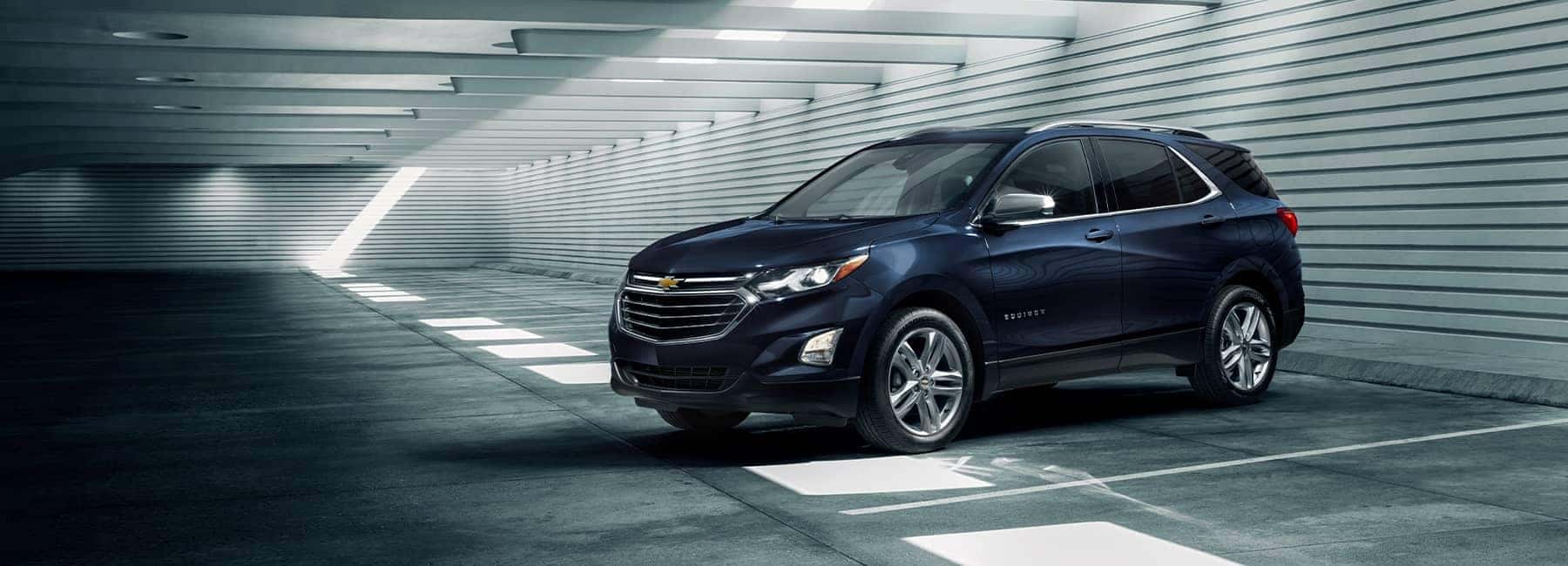 A blue 2021 Chevrolet Equinox parked inside a parking garage
