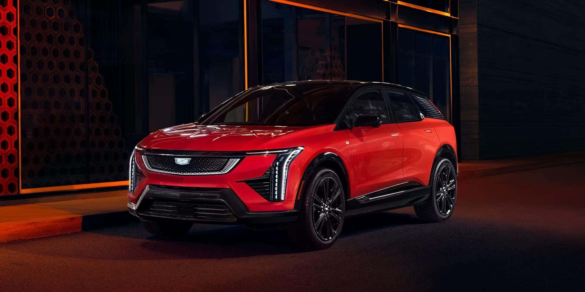 2027 Cadillac OPTIQ in red at night, front driver side
