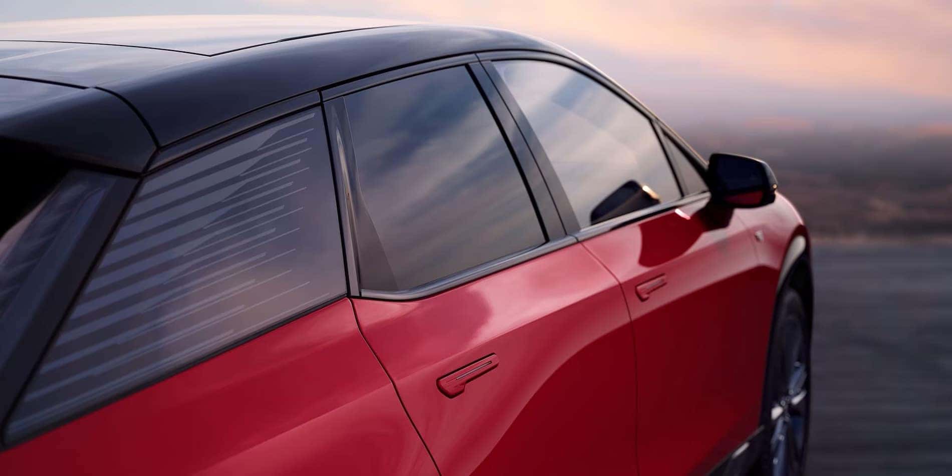 2027 Cadillac OPTIQ passenger-side window and body detail in red