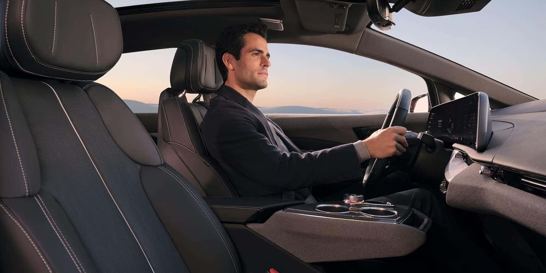 Driver at the wheel of a 2027 Cadillac OPTIQ with black Inteluxe seats