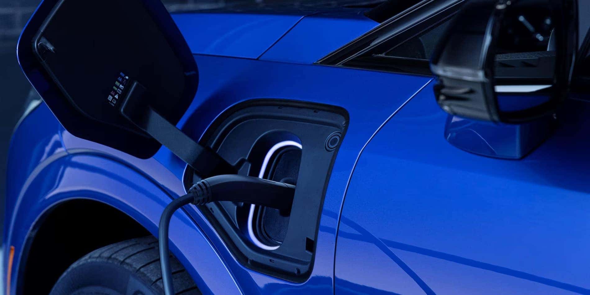 2027 Cadillac OPTIQ-V in blue with its native NACS charge port connected