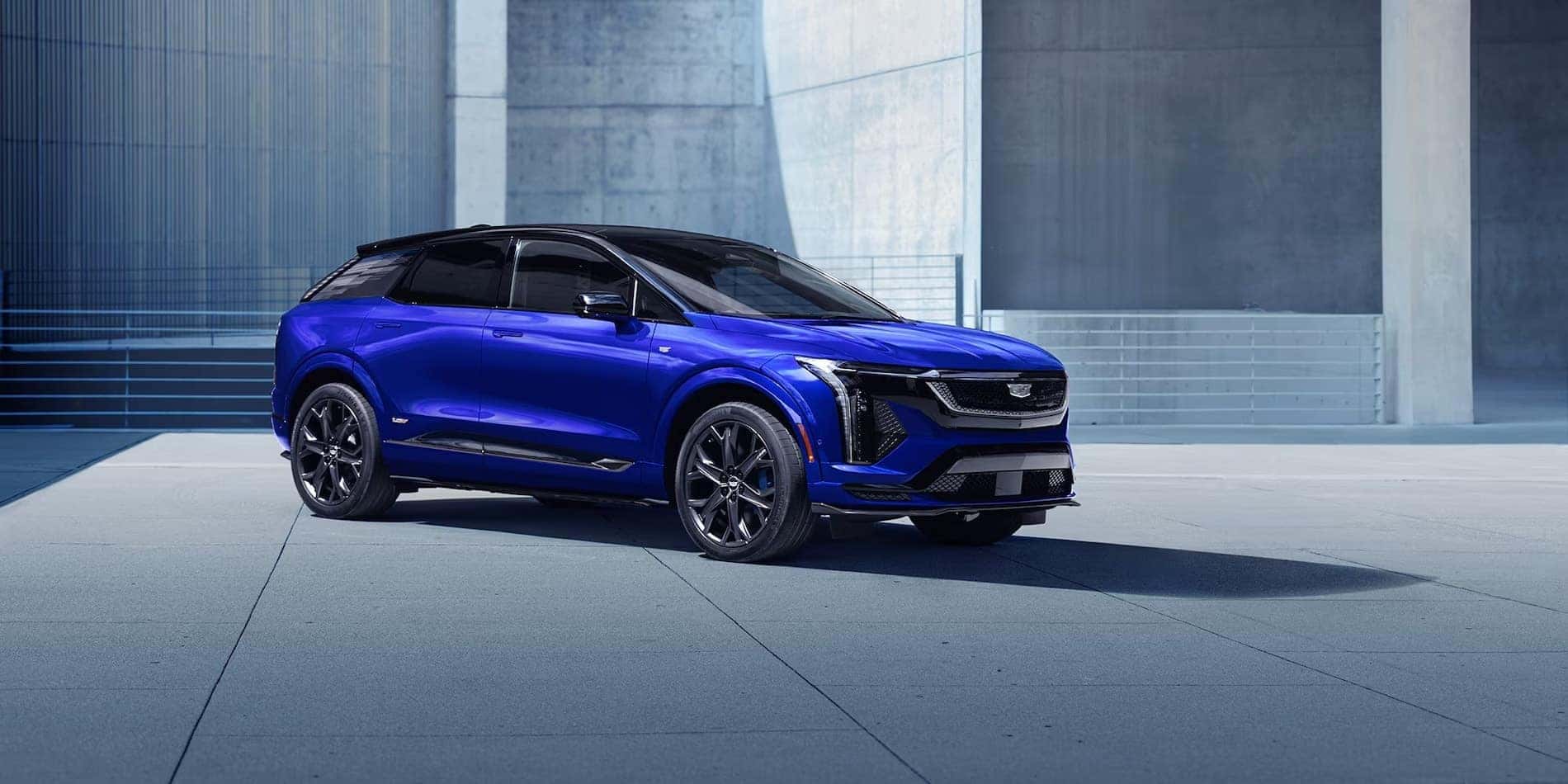 2027 Cadillac OPTIQ-V in blue, side profile showing the 21-inch V-Series wheels