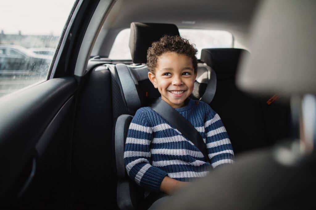 Young boy excited to be going on a car ride.