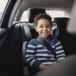 Young boy excited to be going on a car ride.