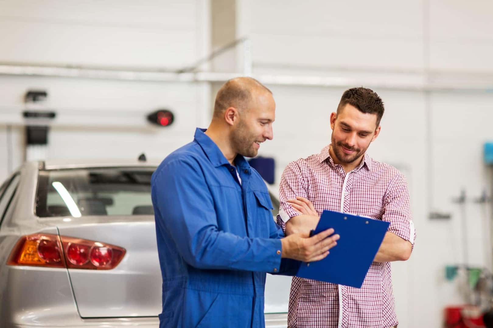 Technician Explaining Electric Car Service Needs to Customer