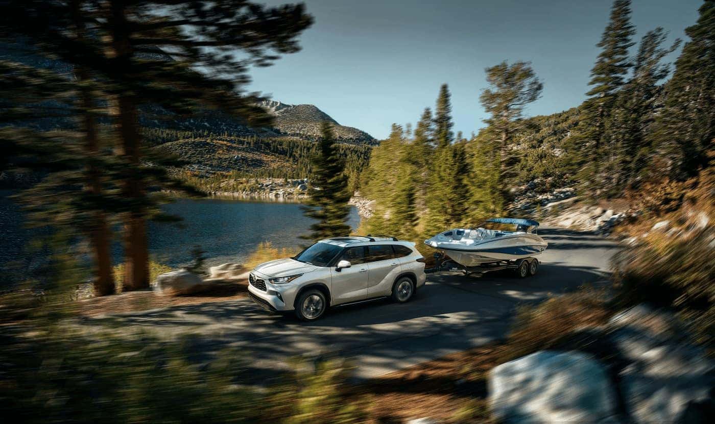 Toyota Highlander towing a boat by the lake
