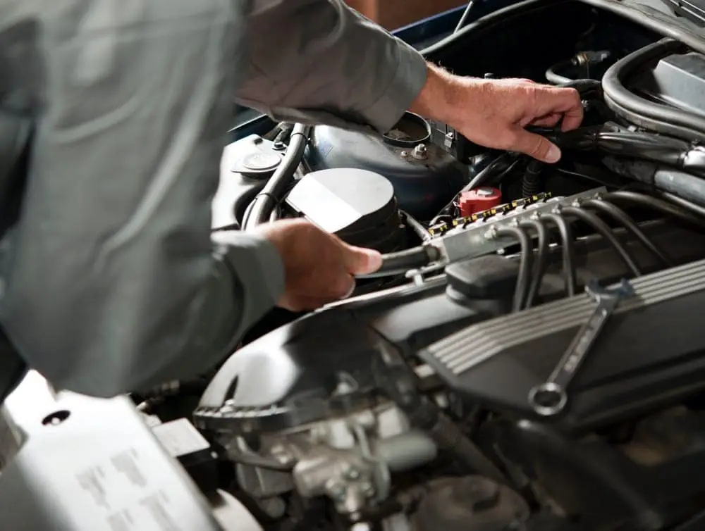 Mechanic reaching into front hood