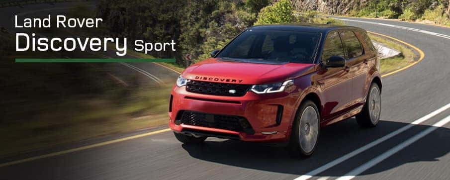 A red Land Rover Discovery Sport driving on a road