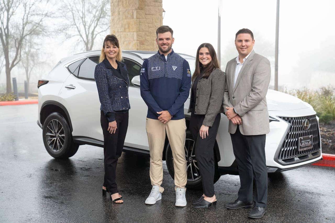 Group standing beside white SUV