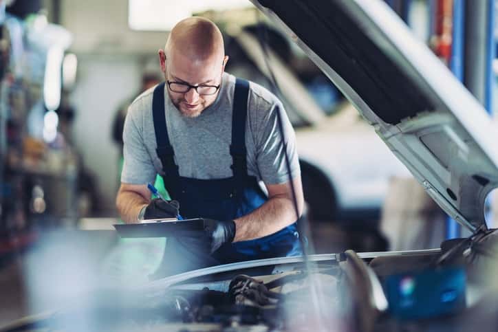 technician inspecting vehicle checklist