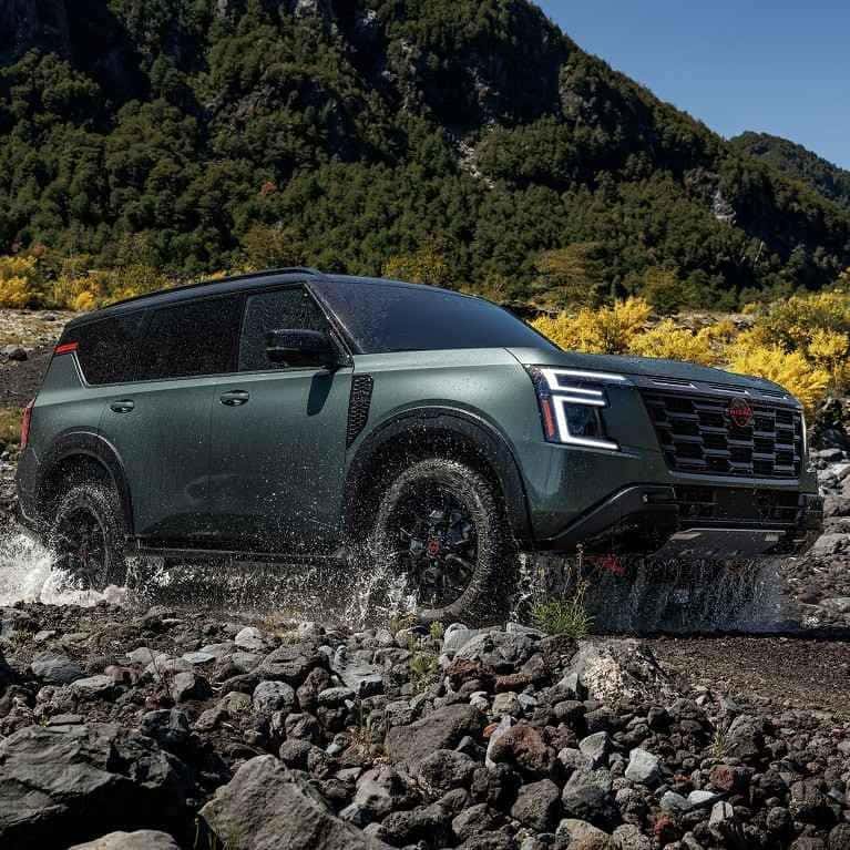 2026 Nissan Armada SUV driving through a rocky stream, highlighting rugged performance and confidence in St. George, UT