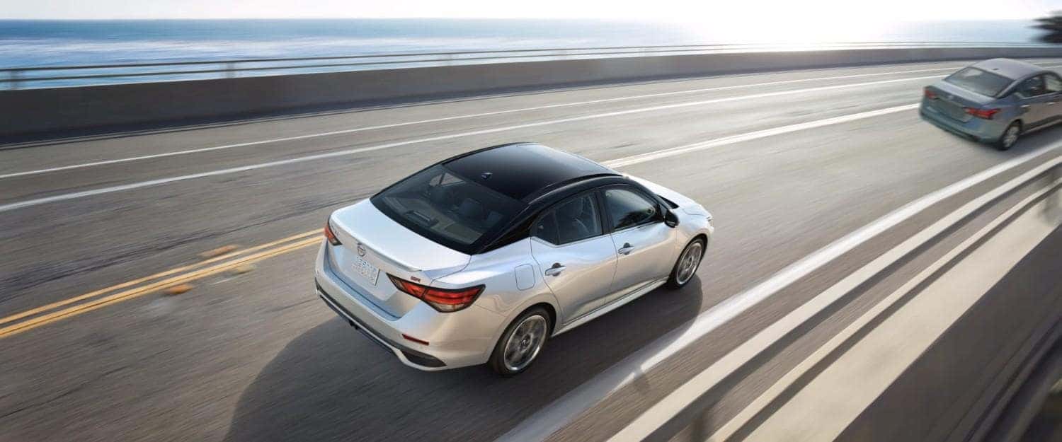 White 2026 Nissan Sentra sedan driving on a highway, showcasing smooth performance and efficiency in St. George, UT