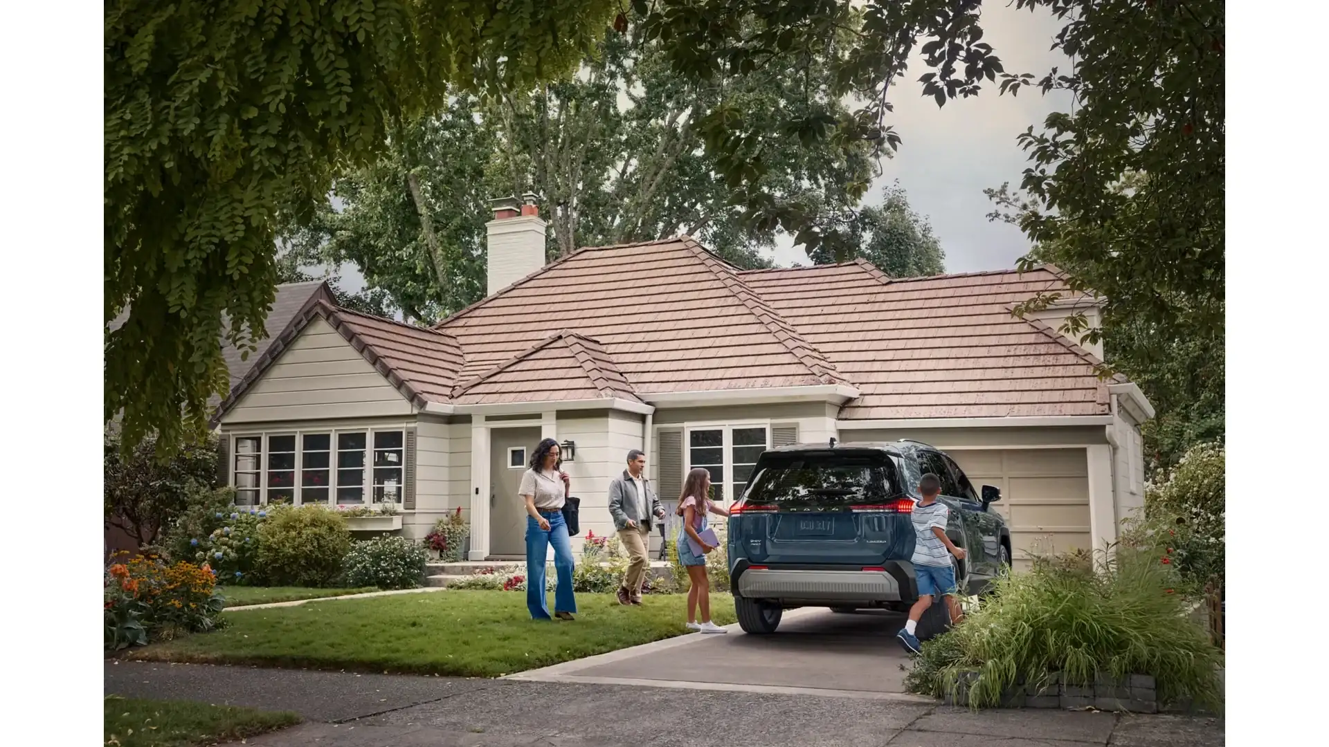 2026 Toyota RAV4 parked at a house with the family loading up for the day