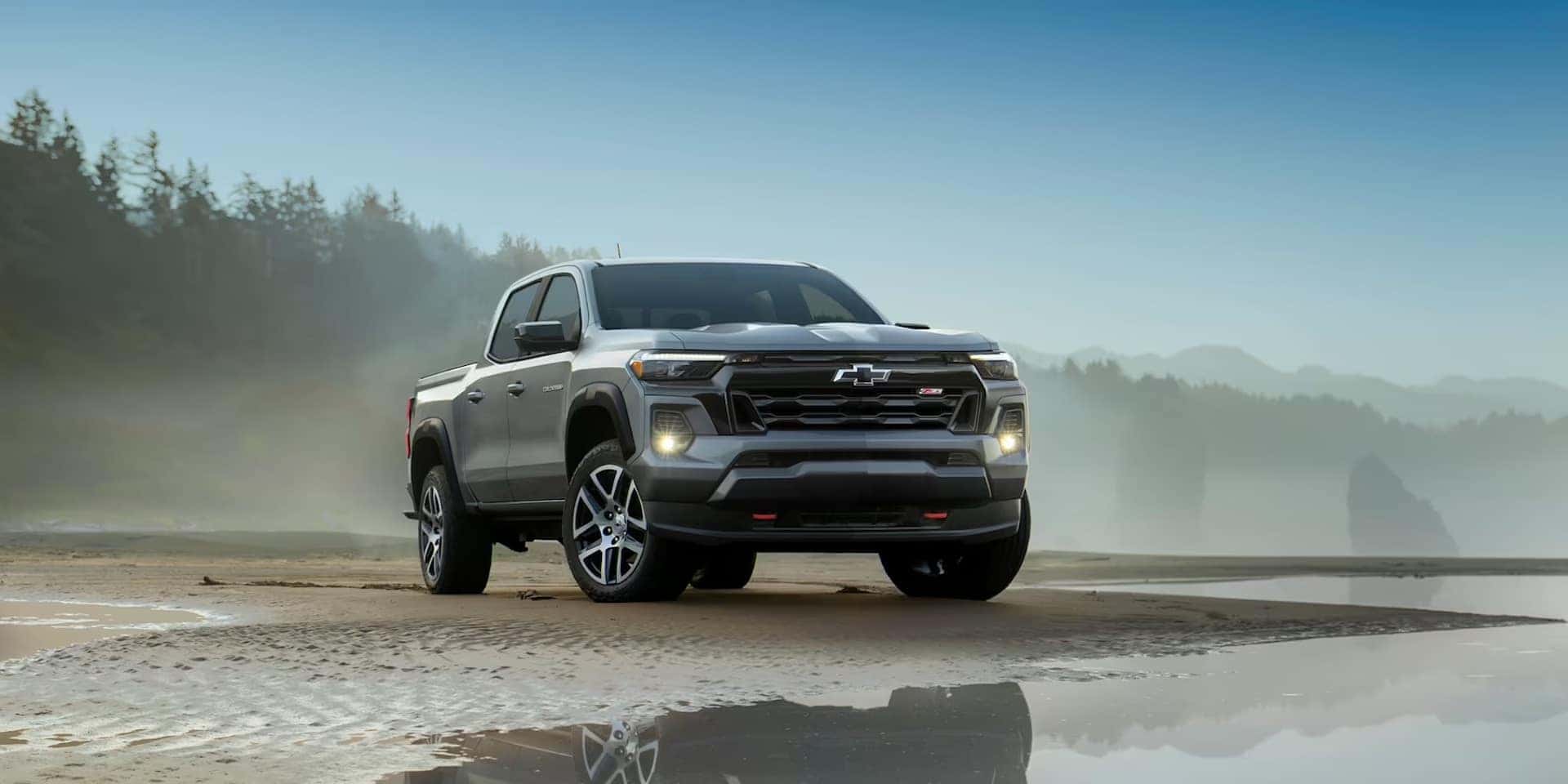 2024 Chevrolet Colorado in Silver parked lakeside in the mountains. 