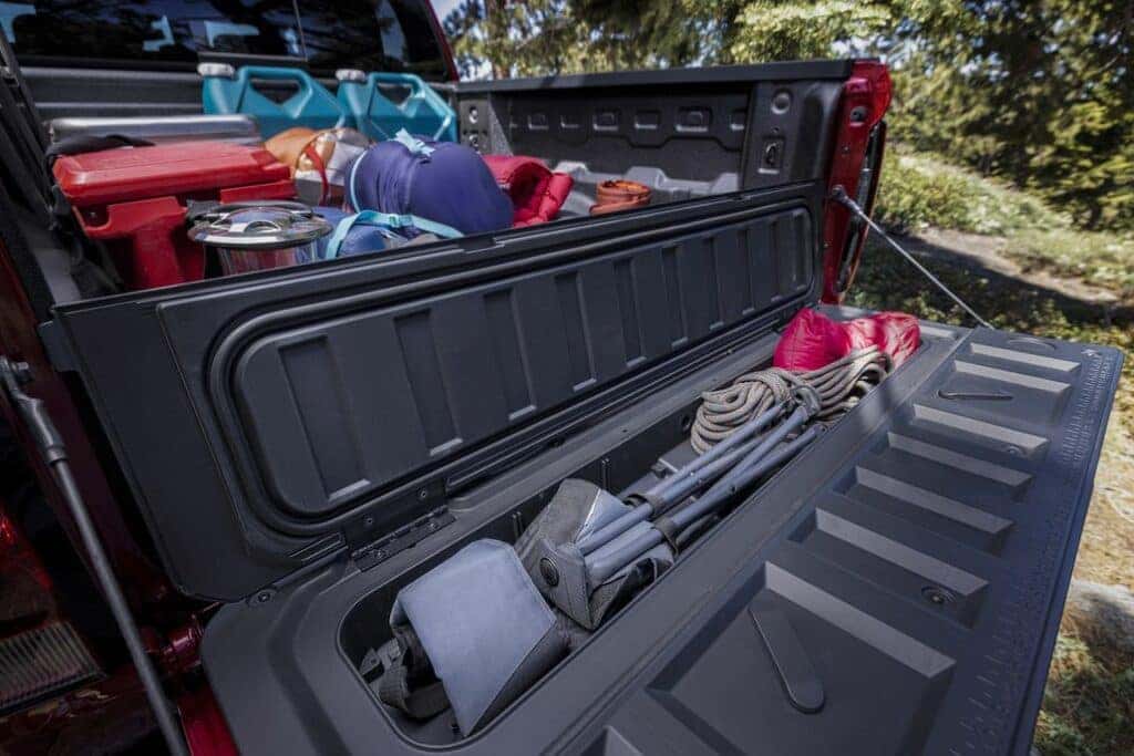 Lifestyle shot demonstrating how to optimize space in the truck bed's unique storage compartements with props.