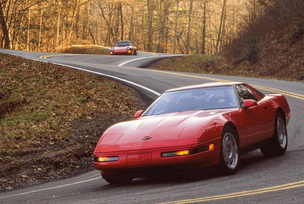 Two Chevrolet C6 Corvette ZR1s Driving on a Forest Backroad Front 3/4 View