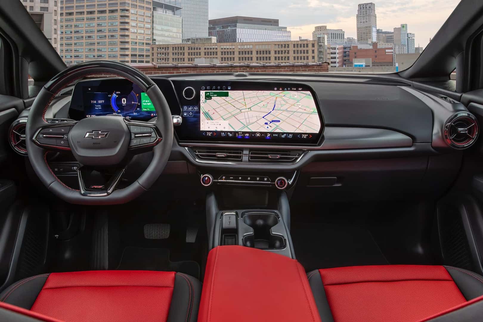 Interior of the Chevy Equinox EV in black and red with view of the cockpit, steering wheel, infotainment, and dash.