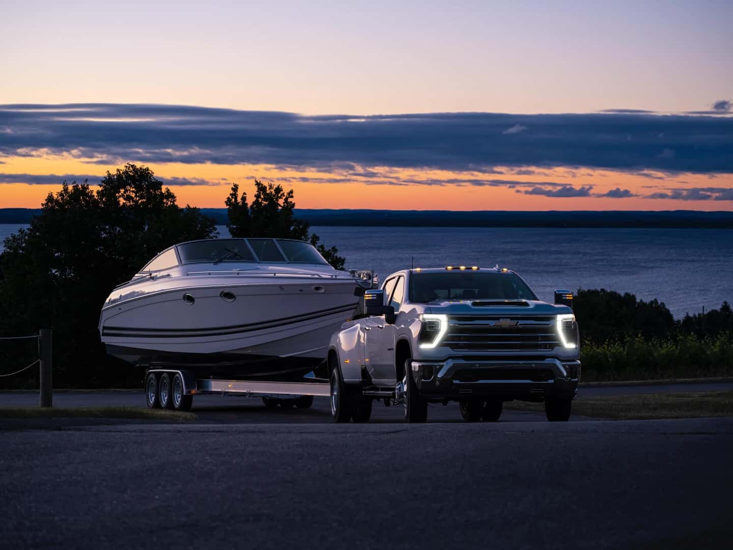 The Glorious 2024 Chevy Silverado 3500 HD Towing A Heavy Boat To The Lake, At Dusk
