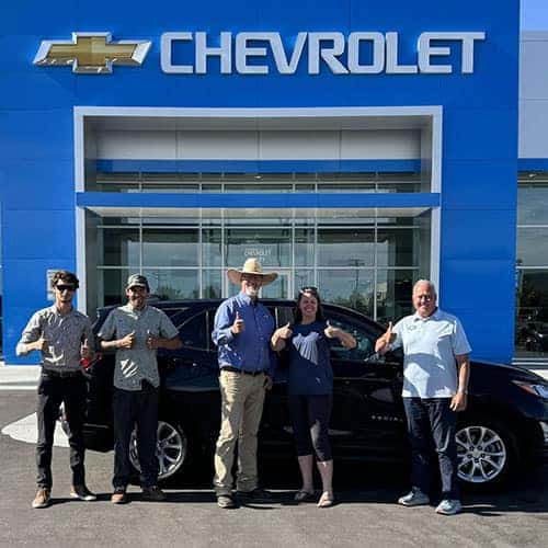 Janel, from Pocatello, Idaho, with her Midnight Blue Metallic 2021 Chevy Equinox FWD LS along with Product Specialist Brian Walker in front of Twin Falls Chevrolet - the Magic Valley's #1 Chevy Dealer, located in Twin Falls, Idaho.