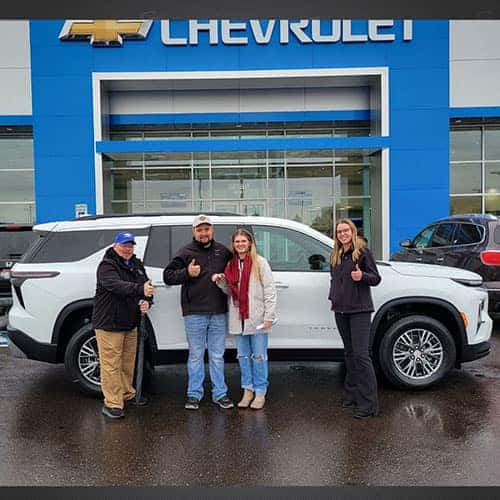 Ashley & Perry, from Paul, Idaho, with their Summit White 2025 Chevy Traverse LT AWD and Product Specialist Brian Castleberry in front of Twin Falls Chevrolet, in Twin Falls, Idaho.