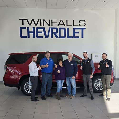 Sabrina, from Burley, Idaho, with Product Specialist Brian Castleberry, inside the delivery bay at Twin Falls Chevy, with their Radiant Red Tintcoat 2025 Chevy Tahoe LT.