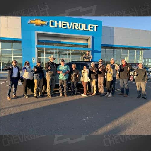 Wendy & Steve, from Buhl, Idaho, with their Sterling Metallic 2023 GMC Acadia AT4 AWD and Product Specialist Brian Walker in front of Twin Falls, Idaho's Twin Falls Chevrolet