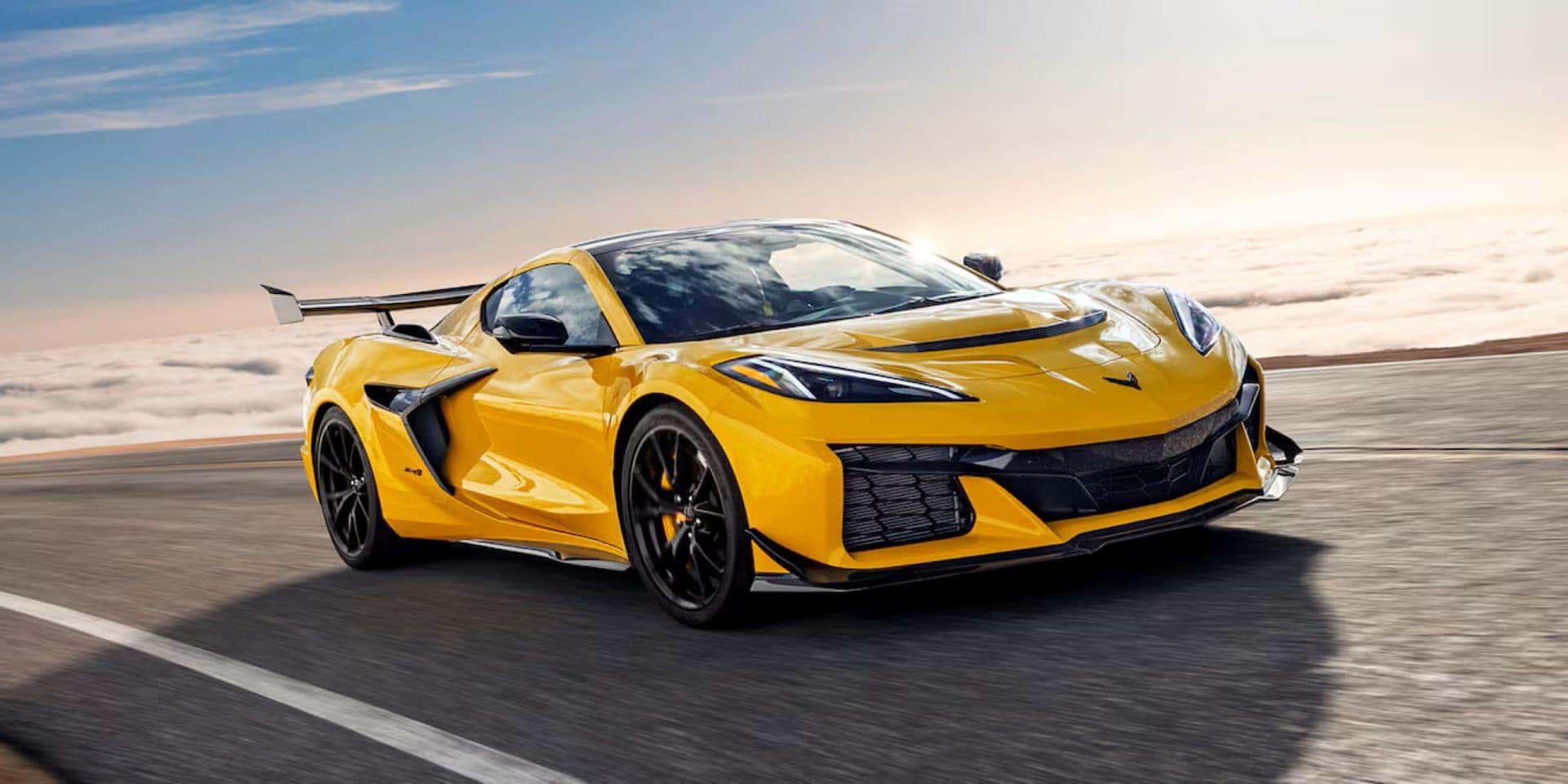A Yellow 2025 Chevy Corvette, Driving On A Road In The Clouds
