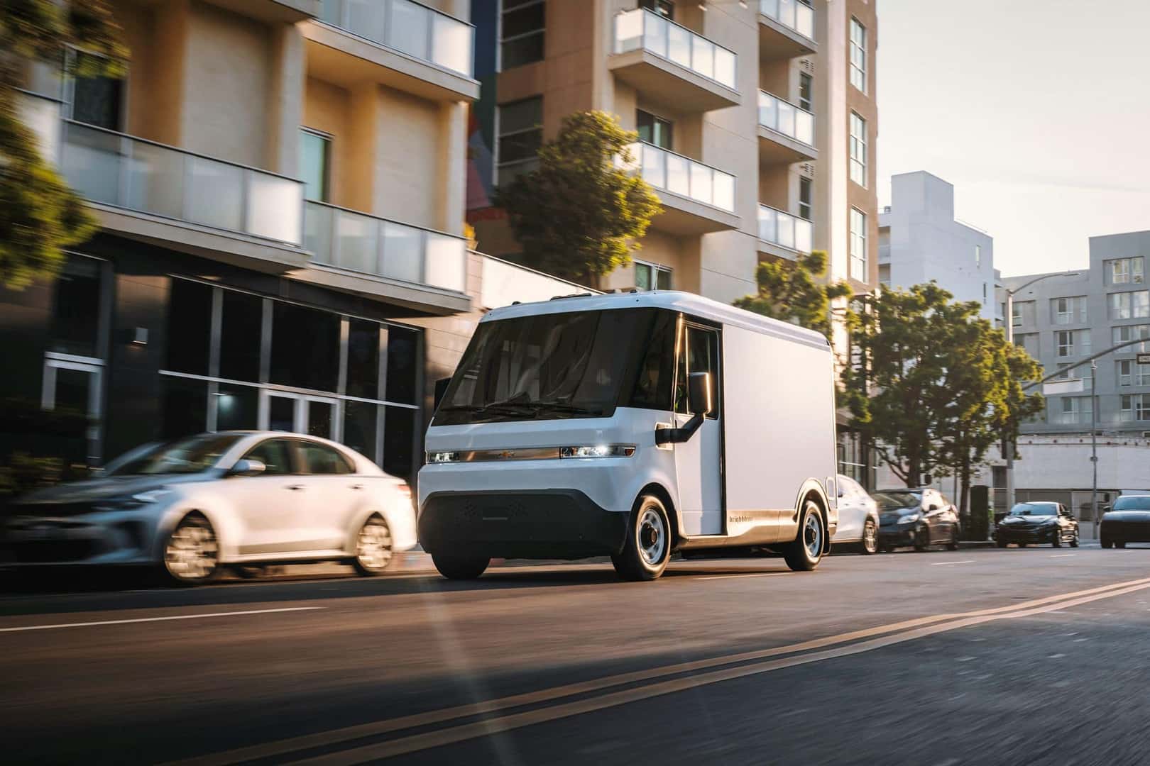 A Cute White Chevy BrightDrop Driving Through The City's Downtown