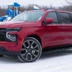 2025 Chevrolet Suburban RST red parked in snow