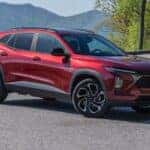 The Practical 2024 Chevrolet Trax, Parked In View Of Vast Mountains And High Trees.