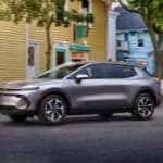 The Versatile And Affordable 2026 Chevrolet Equinox EV, Parked Near a Yellow And A Blue Building