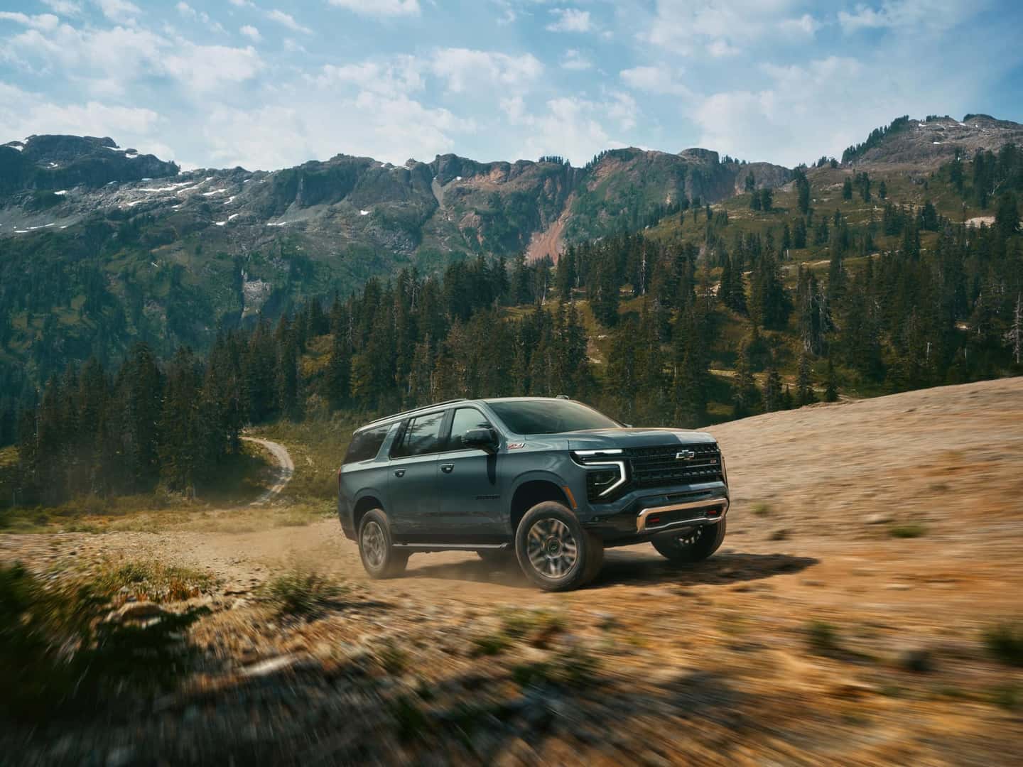 The Family-Friendly And Adventurous 2026 Chevrolet Suburban Driving off-Road Past Forests And Mountains