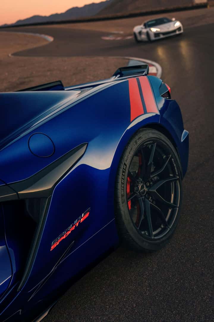 The High Torque Chevrolet Corvette Taking A Turn On A Reflective Concrete Road, At Dusk