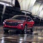 The Budget-Friendly And Affordable 2024 Chevrolet Trax's Red Exterior, Driving On A Wet Road With Grace And Style