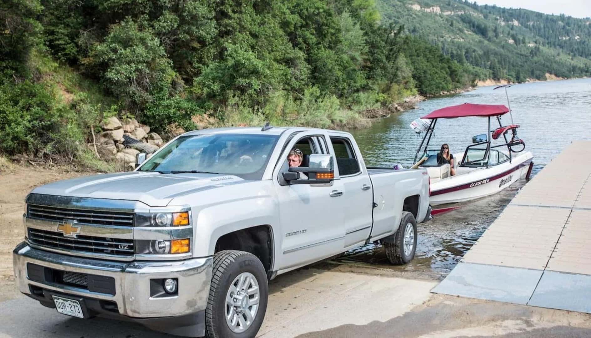 A Muscular And Powerful Chevy Truck Backing The Prepared Boat Trailer Into The Lake
