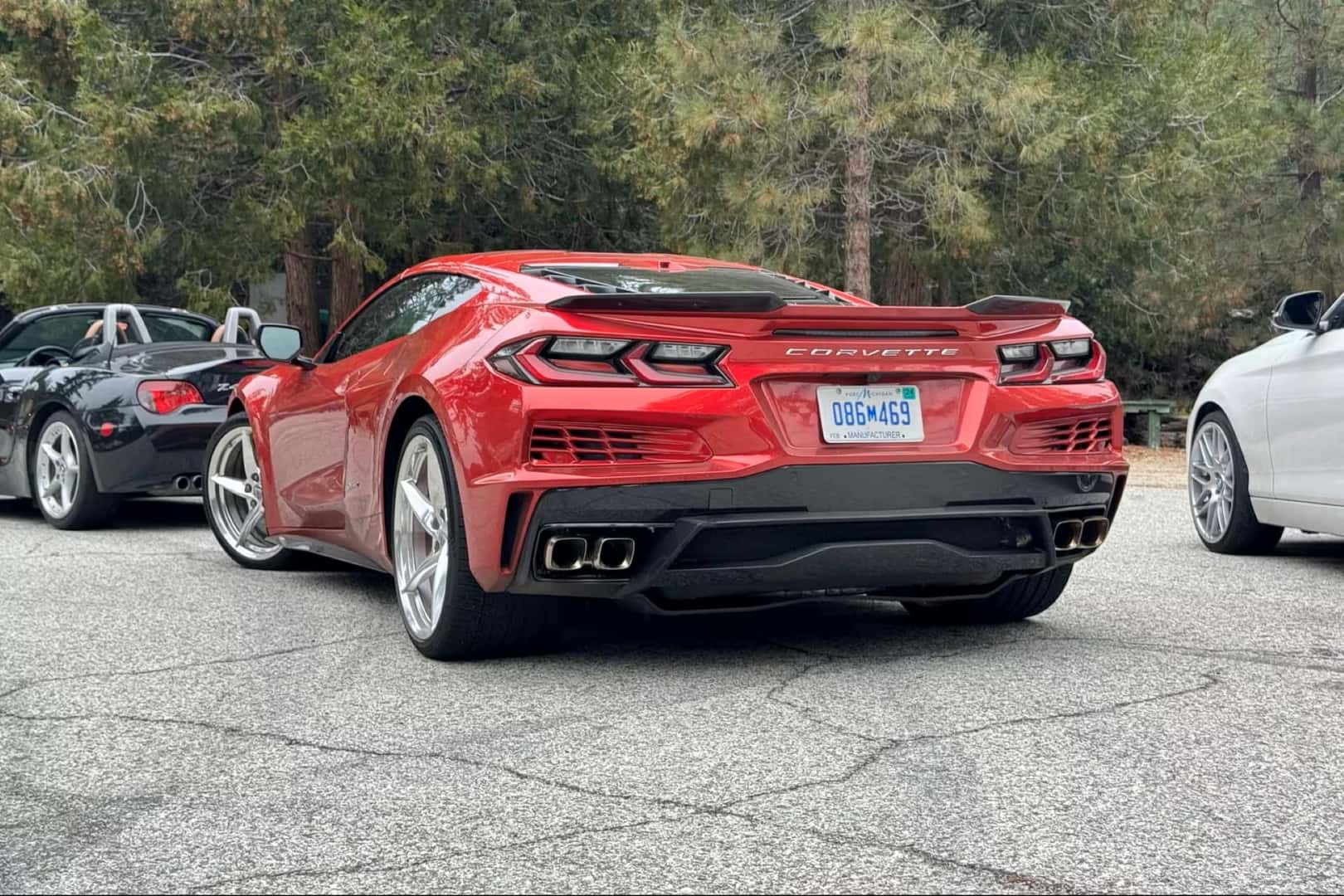 The Charming Red Chevrolet Corvette E-Ray's Rear, Parked In A Parking Lot With Other Corvettes