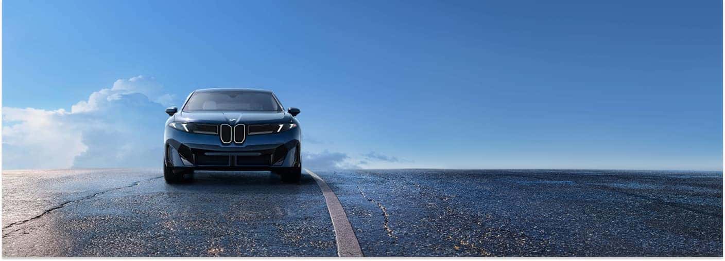 2027 BMW iX3 Driving on Road with Clear Skies